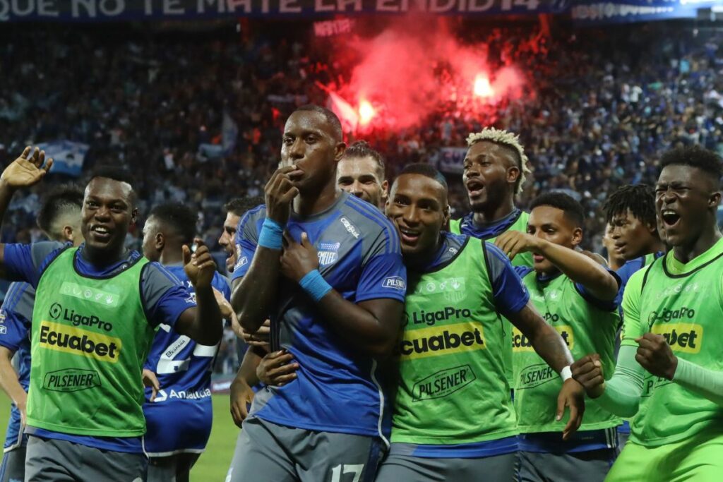 Jaime Ayoví celebra un gol de Emelec con las bengalas de la sanción de fondo. Foto: API