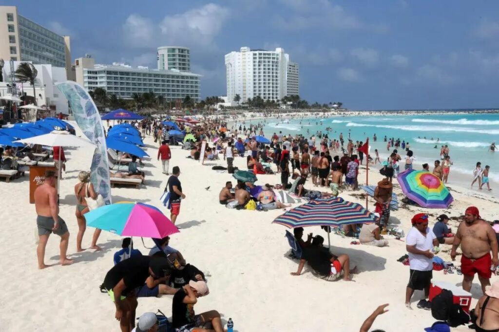 Imagen de turistas disfrutando de una playa en Cancún, México.