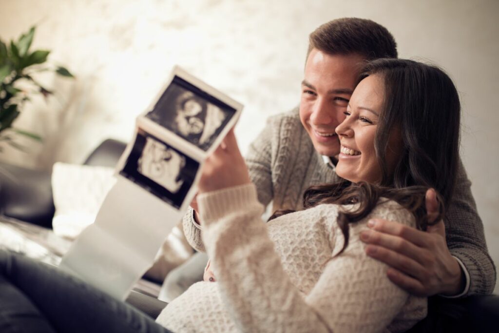 Imagen de una pareja emocionada viendo una ecografía fetal