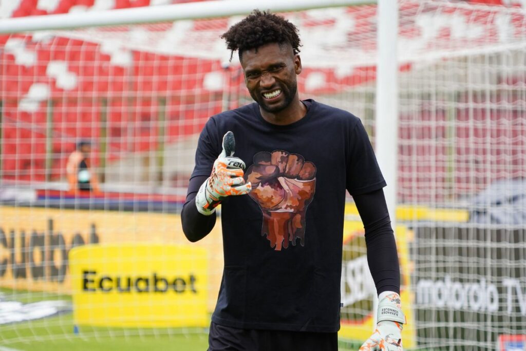 Imagen de Alexander Domínguez con una camiseta en contra de la discriminación durante el calentamiento de un partido con su equipo.