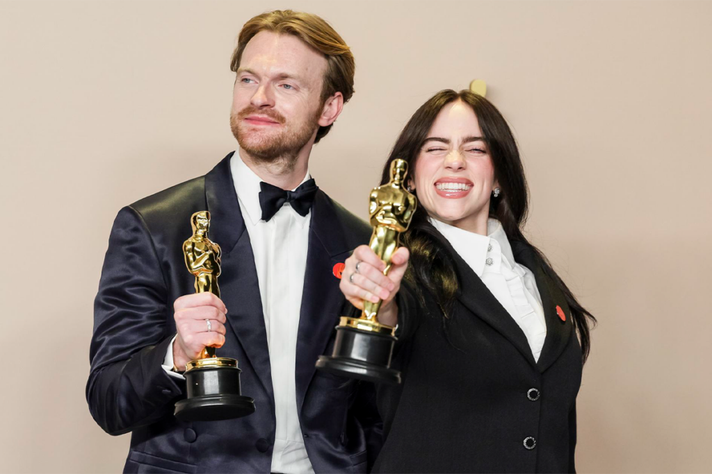 Fotografía de los artistas posando juntos en un evento especial.