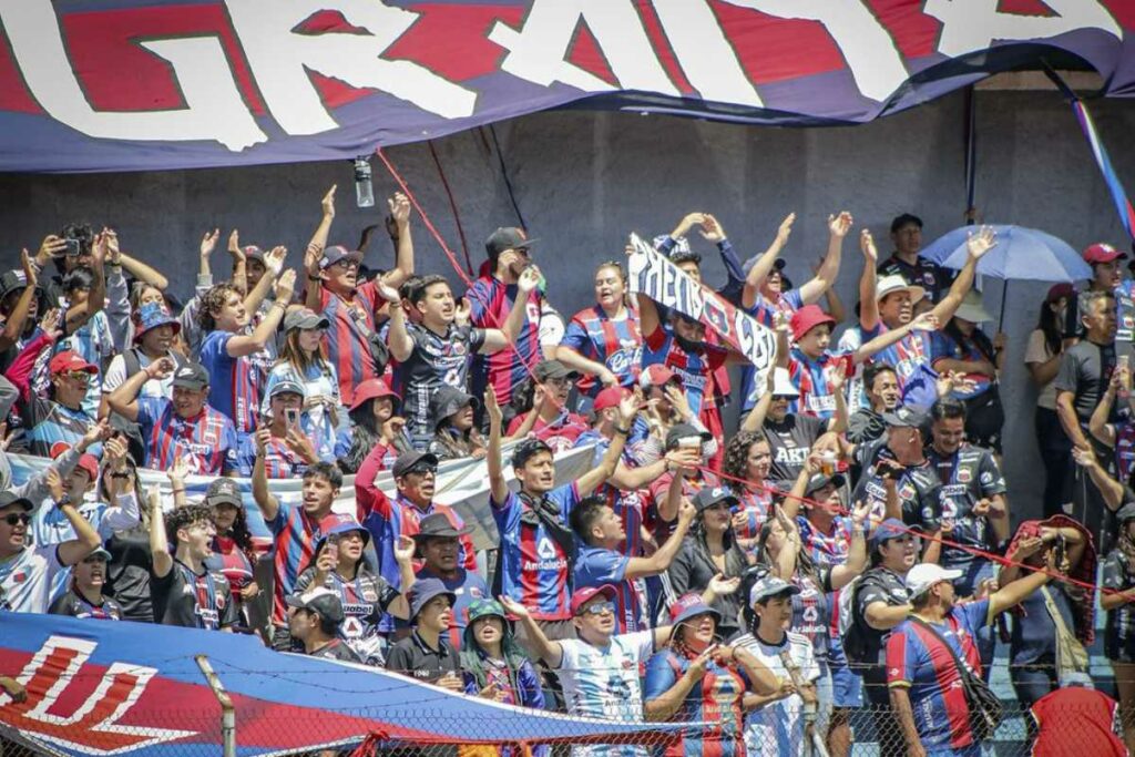 Aficionados apoyando al equipo de fútbol en un emocionante partido en el 2024.